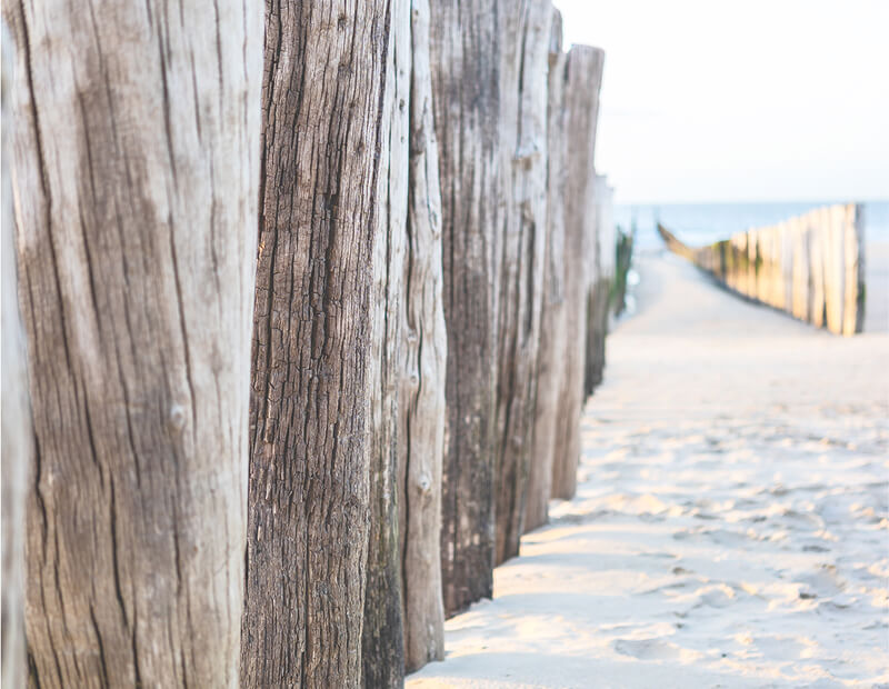frau-hotelmitarbeiter Holzpfade am Strand